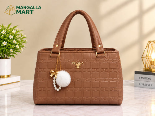 Elegant Pink Women’s Handbag with Gold Accents & Pom-Pom Charm